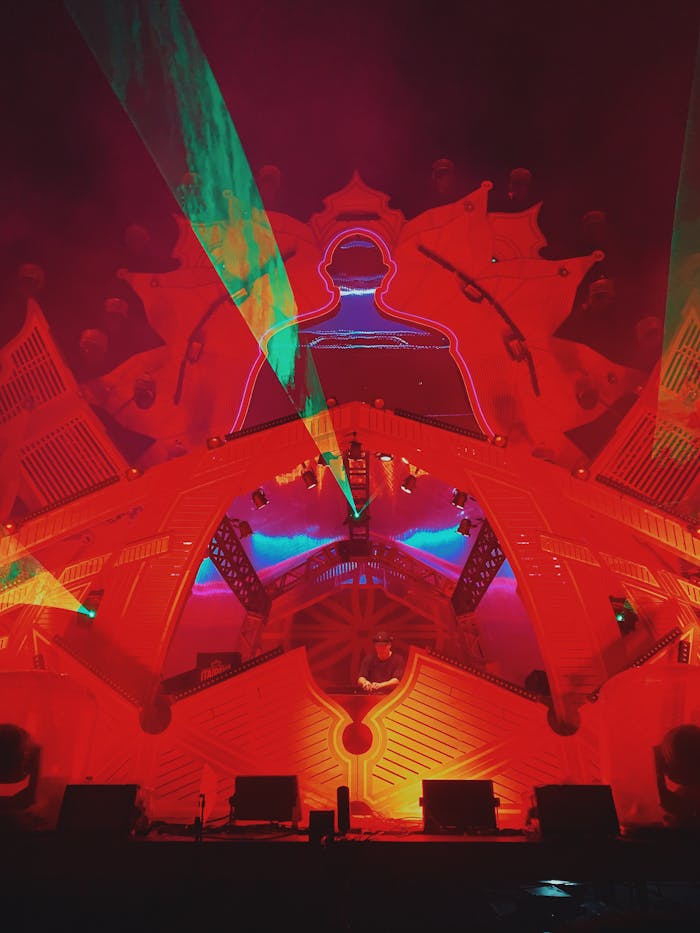 The Art of Drawing Readers In: Your attractive post title goes here Dynamic laser and light display with a red structure, creating vibrant visual effects at a nighttime event.