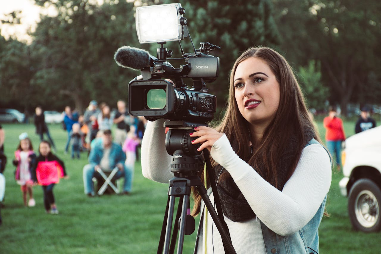 Mastering the First Impression: Your intriguing post title goes here A female videographer operates a professional camera outdoors, capturing live events with precision.